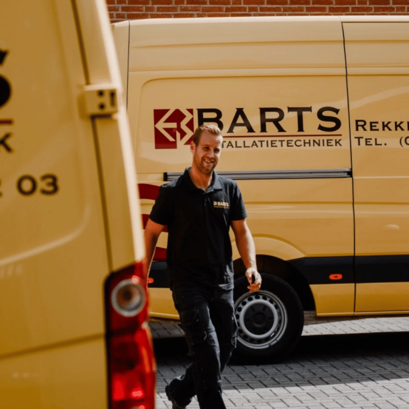 Een medewerker van Barts tussen de gele bedrijfsbussen